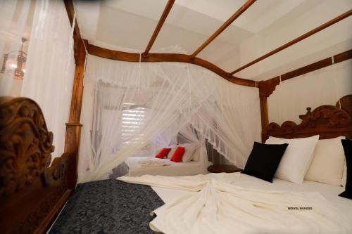 Florain Otium Talpe - 3 Bedroom Oceanfront Villa في يوناواتونا: غرفة نوم بسريرين عليها شبك