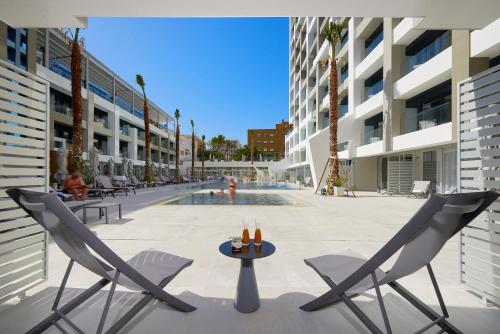 a patio with chairs and a table and a pool at INNSiDE by Meliá Palma Bosque in Palma de Mallorca