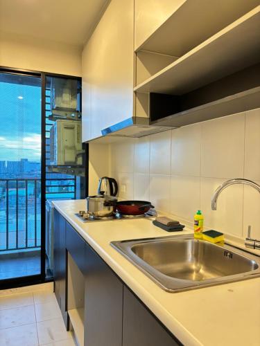 a kitchen with a sink and a large window at Entire apartment near train station with pool & views in Ban Song Hong