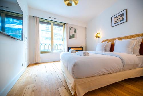 une chambre avec un grand lit et une grande fenêtre dans l'établissement CIA - Saint Germain Montparnasse, à Paris