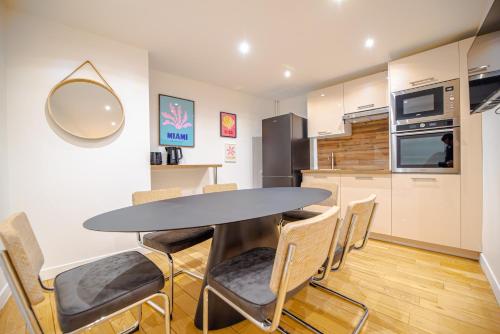 une cuisine et une salle à manger avec une table et des chaises dans l'établissement CIA - Saint Germain Montparnasse, à Paris