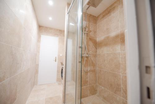 une douche avec une porte vitrée dans une salle de bain dans l'établissement CIA - Saint Germain Montparnasse, à Paris