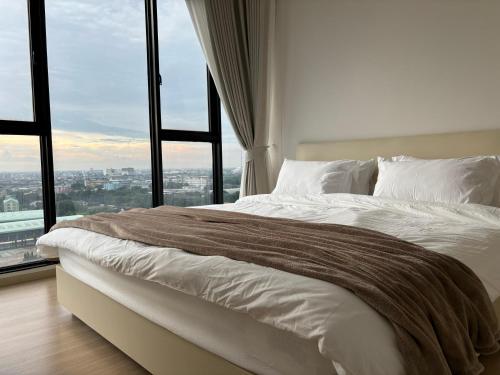 เตียงในห้องที่ Entire apartment near train station with pool & views