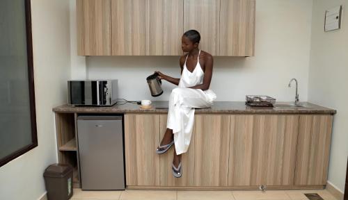 a woman sitting on top of a kitchen counter at Micassa Suites in Kampala