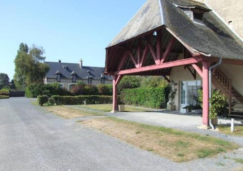 a building with a red roof and a road at Appartement lumineux et cosy avec jardin vue sur chateau près Port en Bessin, Bayeux et Omaha Beach in Commes
