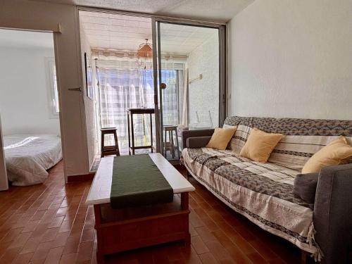 un salon avec un canapé et une table dans l'établissement Appartement Studio cabine 4 couchages ARGELES SUR MER AR020-007, à Argelès-sur-Mer