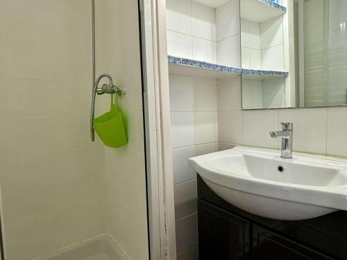une salle de bain blanche avec un lavabo et un miroir dans l'établissement Appartement Studio cabine 4 couchages ARGELES SUR MER AR020-007, à Argelès-sur-Mer