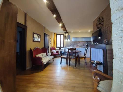 a living room with a table and chairs and a kitchen at Habitation Saint-Clar Vieille Ville in Bergerac