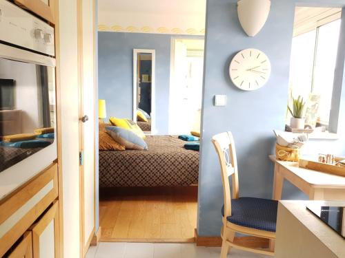 Cette chambre comprend un lit et une horloge murale. dans l'établissement Residence les cotes d'Armor, à Plestin-les-Grèves