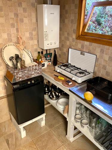 a kitchen with a counter with a stove and a sink at Wild Glamping Portugal com jacuzzi privado Serra de Arga, Viana do Castelo in Viana do Castelo
