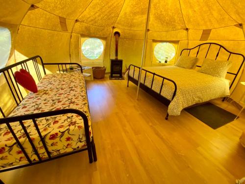 a bedroom with two beds in a tent at Wild Glamping Portugal com jacuzzi privado Serra de Arga, Viana do Castelo in Viana do Castelo