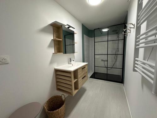 ein weißes Badezimmer mit Waschbecken und Dusche in der Unterkunft Évasion à Hainneville in Cherbourg en Cotentin