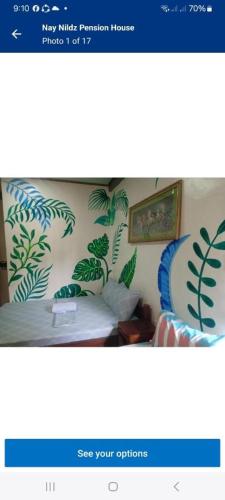 a picture of a bedroom with a bed with plants at Nay Nilda Tourist Inn in Itaytay