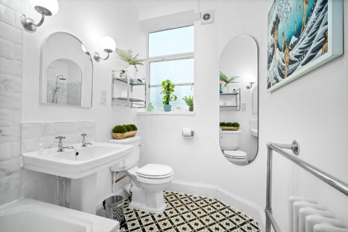 a white bathroom with a sink and a toilet at Stylish Two-Bedroom Apartment with Balcony & Parking 9NC in Birmingham