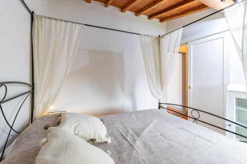 a bedroom with a bed with white walls and a window at Vigna Home Amazing Site Chianti Classico - Happy Rentals in Strada