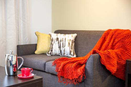 a couch with an orange blanket on it at Lithgow Workies Club Motel in Lithgow