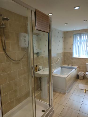 a bathroom with a tub and a sink at San Remo Apartments Blackpool in Blackpool