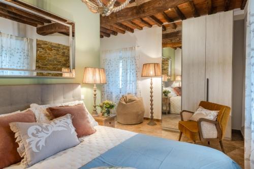 une chambre avec un lit, une chaise et un miroir dans l'établissement Molino Giusti Farmhouse, à Santa Maria del Giudice