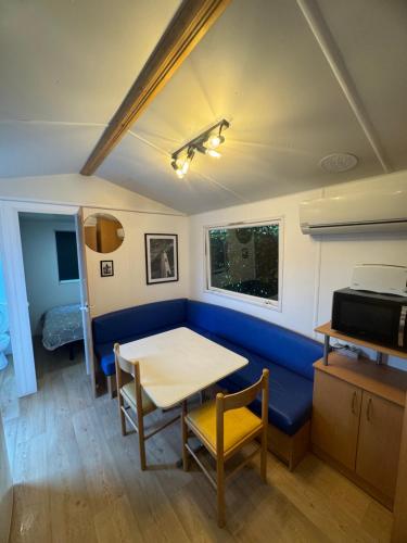 un salon avec un canapé bleu et une table dans l'établissement Mobile-home au bord de la plage, à Martigues