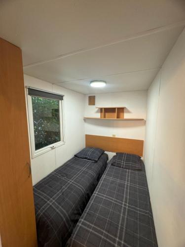 Ένα ή περισσότερα κρεβάτια σε δωμάτιο στο Mobile-home au bord de la plage