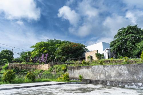 a house on a hill with a stone wall at Estrella Hotel & Conference in Luwuk