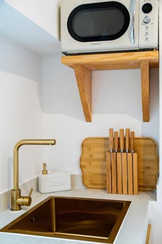 a microwave sitting on a shelf above a kitchen sink at Casa Do Beco in Moura