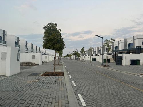 a street with a tree in the middle of a road at Al Dana villa in Fujairah