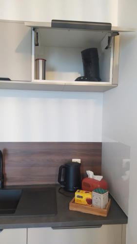 a kitchen counter with a shelf with food on it at Bois de rose in Theux
