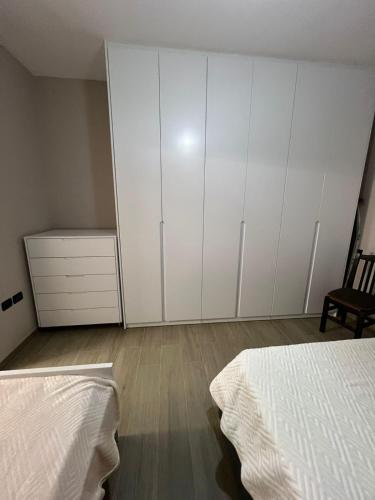 sypialnia z dwoma łóżkami i białymi szafkami w obiekcie Large Apartment we Wlorze