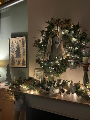 a christmas wreath on a table with a fireplace at The Lake house Feneos in Archaia Feneos