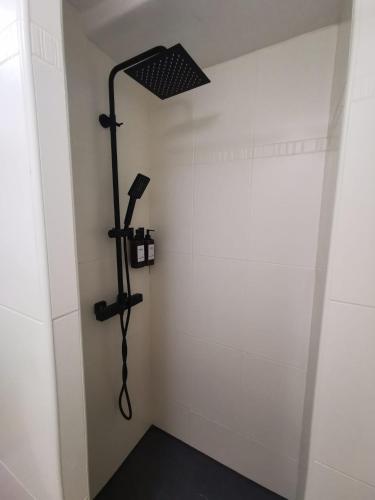 Cette chambre blanche dispose d'une douche. dans l'établissement Le Splendide Cosy Room, à Aix-les-Bains