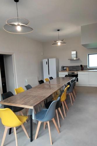 une salle à manger avec une grande table et des chaises en bois dans l'établissement Gîte de Briante, à Saint-Lager