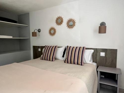 a bedroom with a bed with two mirrors on the wall at Résidence Storia di Blue in Porto-Vecchio