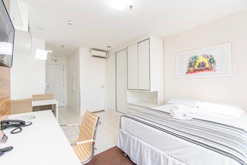 a hotel room with a bed and a desk at Vision Hotel em Brasília 59854 in Brasilia