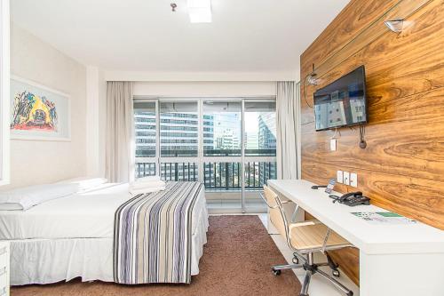 a hotel room with a bed and a desk and a window at Vision Hotel em Brasília 59854 in Brasilia