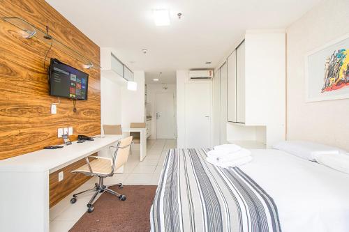 a room with a bed and a desk and a tv at Vision Hotel em Brasília 59854 in Brasilia