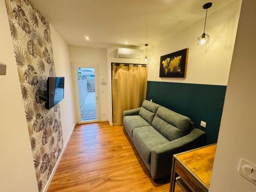 un salon avec un canapé et une télévision dans l'établissement Studio du château climatisée, à Carcassonne