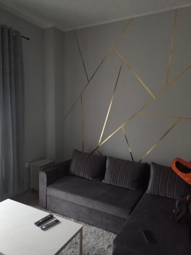 a living room with a couch and a geometric wall at Apartament Dworcowa 39 - GŁÓWNY DEPTAK in Bytom