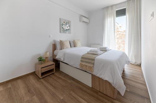 biała sypialnia z dużym łóżkiem i oknem w obiekcie Stylish spacious apartment in Palaio Faliro (C1) w Atenach