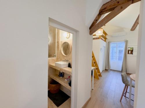 une salle de bain avec un lavabo et un miroir dans l'établissement Loft Élégant & Lumineux dans un Immeuble Classé, à Nîmes