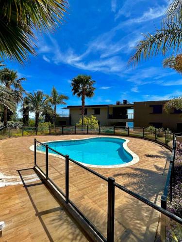 - une piscine dans une cour avec une terrasse en bois dans l'établissement Cosy 2 pièces au port de la Figueirette, à Théoule-sur-Mer