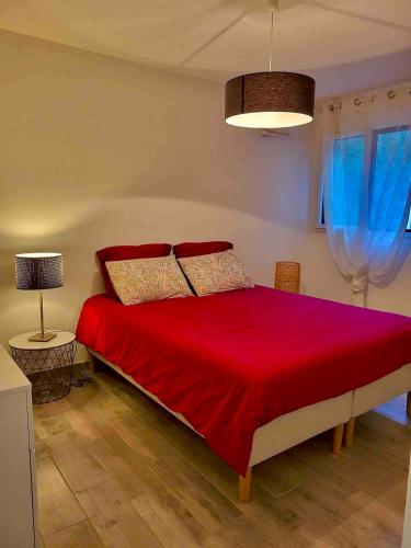 - une chambre avec un lit rouge et des rideaux bleus dans l'établissement Cosy 2 pièces au port de la Figueirette, à Théoule-sur-Mer