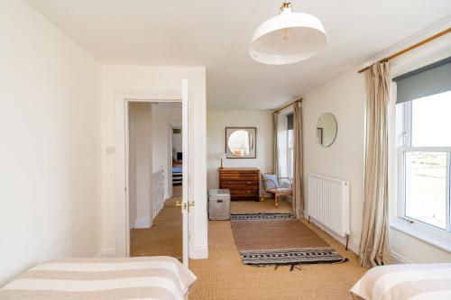 a bedroom with two beds and a hallway at No6 Sea Lane in Embleton