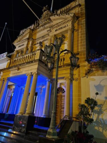 a building with blue lights on the front of it at Ancient Maltese House with modern interior 3 min away from Airport TAL-PINU in Gudja