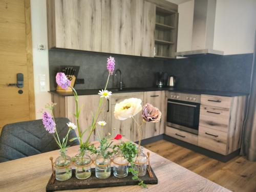 a kitchen with a table with flowers in vases on it at Berwang 1336 Apartments in Berwang