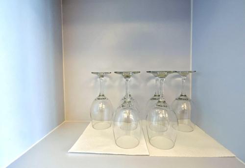 four wine glasses are sitting on a shelf at Stylish 2BR Apartment ARC100 Surabaya City Centre with Balcony by Le Ciel Hospitality in Surabaya