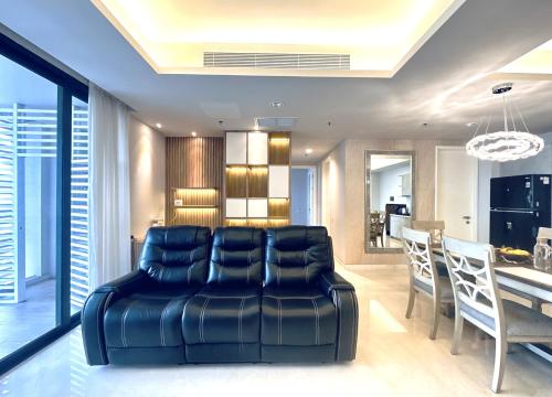 a living room with a leather couch and a table at Stylish 2BR Apartment ARC100 Surabaya City Centre with Balcony by Le Ciel Hospitality in Surabaya