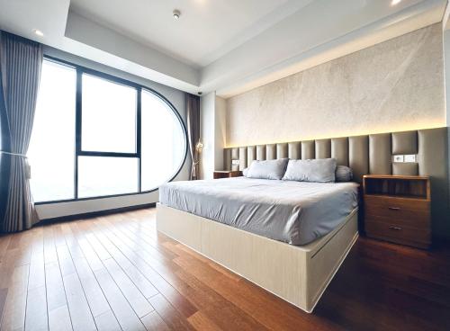 a bedroom with a large bed and a large window at Stylish 2BR Apartment ARC100 Surabaya City Centre with Balcony by Le Ciel Hospitality in Surabaya