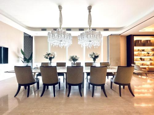 a dining room with a table and chairs and chandeliers at Stylish 2BR Apartment ARC100 Surabaya City Centre with Balcony by Le Ciel Hospitality in Surabaya
