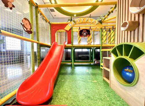 a playground with a red slide in a room at Stylish 2BR Apartment ARC100 Surabaya City Centre with Balcony by Le Ciel Hospitality in Surabaya